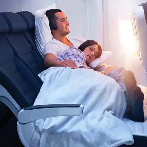 Couple endormi sur plusieurs sieges pendant un voyage en avion